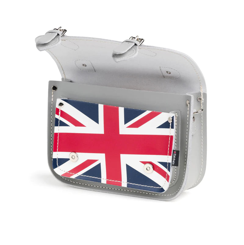 An open satchel bag, in grey, featuring the Union Jack on the front pocket