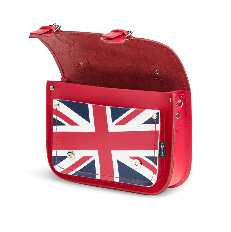 An open satchel bag, in red, featuring the Union Jack on the front pocket