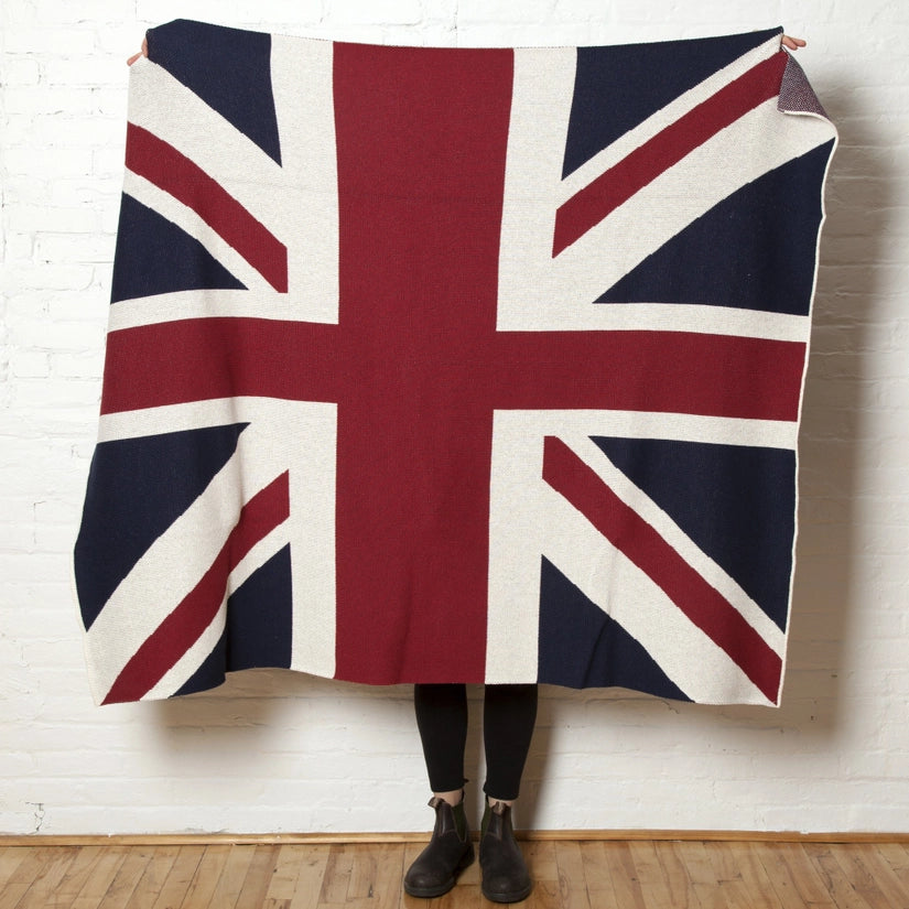 A person holding a throw featuring the Union Jack