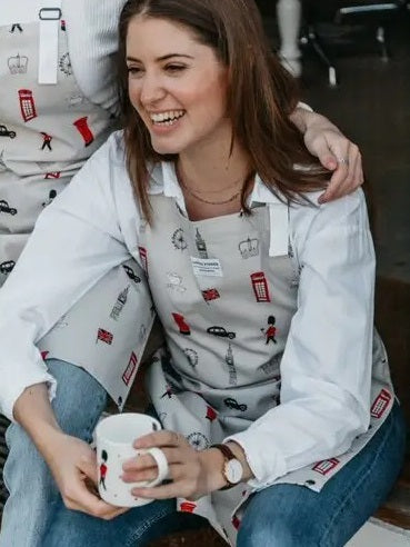 A woman wearing an apron with illustrations of London's iconic landmarks